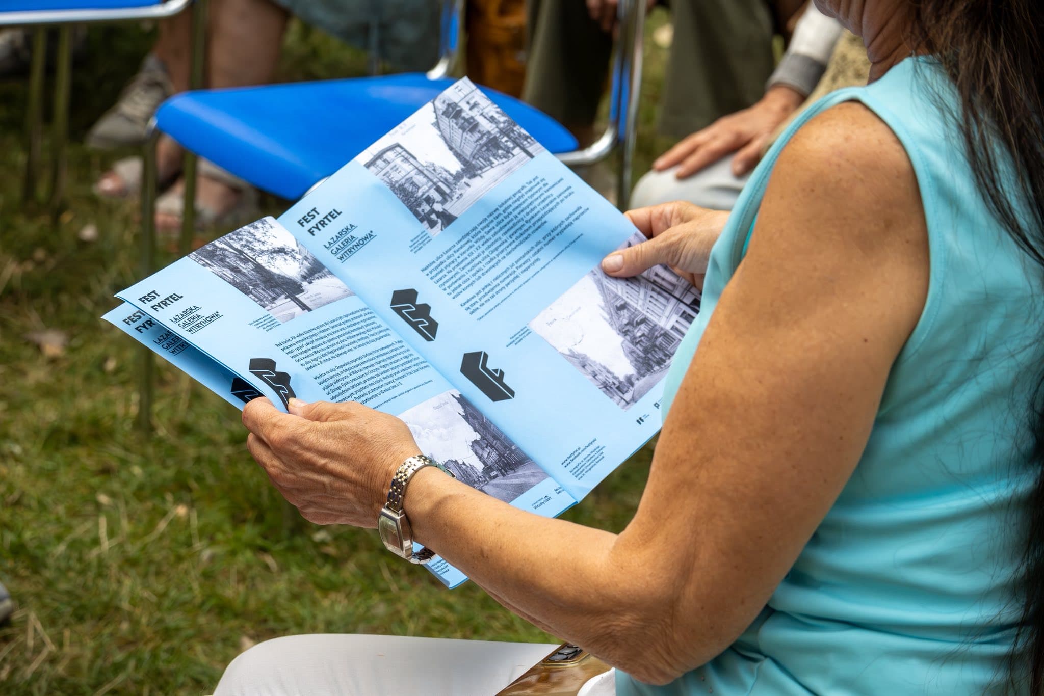 Uczestniczka czyta ulotkę z instrukcjami bezpieczeństwa pożarowego