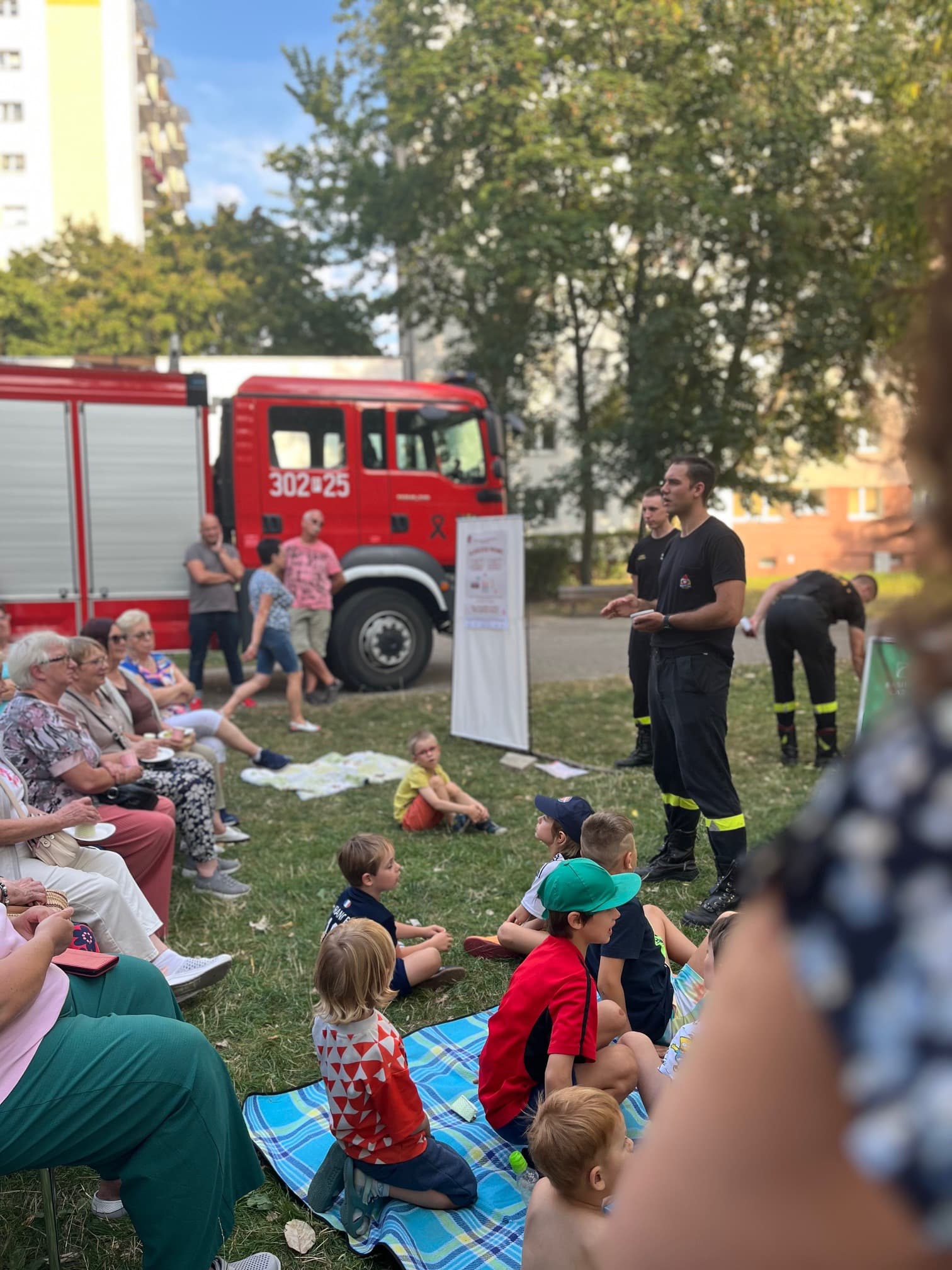 Wóz strażacki i tłum uczestników podczas pikniku sąsiedzkiego